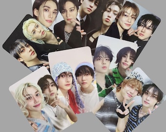 May include: A set of photo cards featuring a group of young men. The cards are arranged in a random pattern and show the men in various poses and outfits. Some of the cards feature the men wearing hats and scarves.