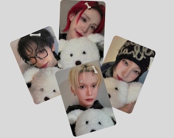 May include: Four photo cards featuring individuals with different hairstyles and accessories, each holding a white teddy bear. The cards have a light gray background. The individuals have red, blonde, and black hair.