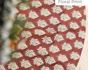 May include: A close-up of a fabric with a repeating leaf pattern. The leaves are white with black outlines, set against a reddish-brown background. The text "Floral Print" is in a white rectangle.