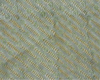 May include: A light sage green fabric featuring a repeating diagonal pattern of small yellow and white floral motifs interspersed with delicate leaf vines. The text at the bottom reads PRINT - TARU and FABRIC - PURE LINEN 58" WIDE.