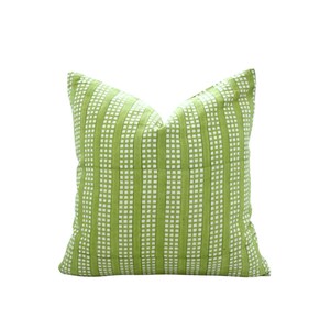 May include: A square decorative pillow with a green and white striped pattern. The pillow has a grid-like design with vertical green stripes and small white squares. The pillow is a bright, fresh color.