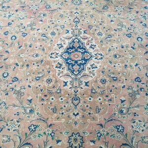 May include: A vintage rug with a floral pattern in shades of pink, blue, and white. The rug has a central medallion with a geometric design.