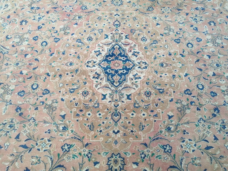 May include: A vintage rug with a floral pattern in shades of pink, blue, and white. The rug has a central medallion with a geometric design.