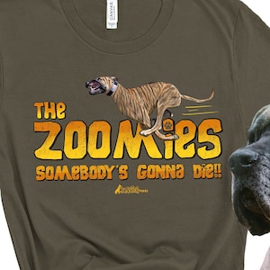 May include: A brown t-shirt with a graphic of a dog running and the text "The Zoomies Somebody's gonna die!" printed on it. A large brown and black dog is sitting next to the shirt.