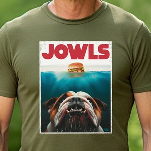 May include: A green t-shirt featuring a vintage-style graphic of a bulldog with the text "JOWLS" above it. The bulldog is underwater with a hamburger floating above it.