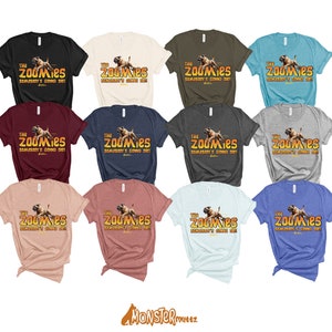May include: A collection of 10 t-shirts in various colours featuring a graphic of a dog running with the text "The Zoomies, Somebody's Going Die!" printed on the front.