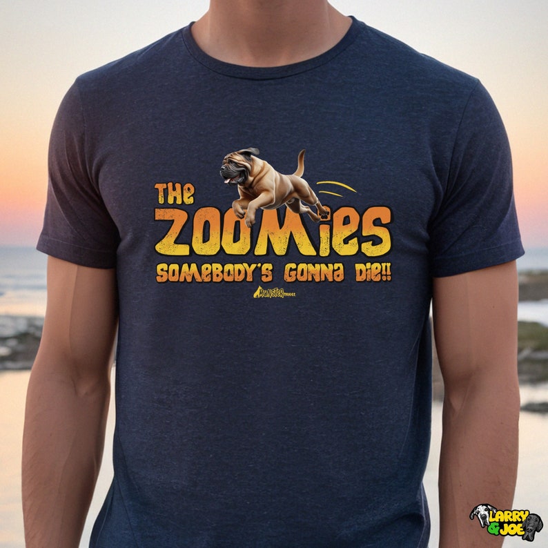 May include: A navy blue t-shirt featuring a cartoon image of a brown and tan dog jumping with the text "The Zoomies Somebody's Gonna Die!" in yellow and orange.