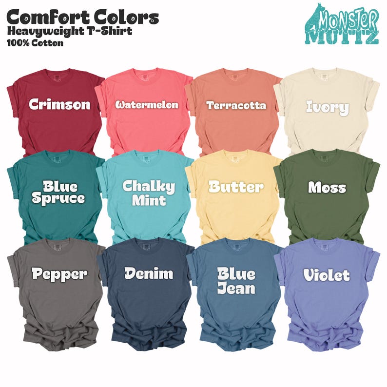 May include: A collection of Comfort Colors heavyweight t-shirts in various colors, including crimson, watermelon, terracotta, ivory, blue spruce, chalky mint, butter, moss, pepper, denim, blue jean, and violet. Each shirt has the color name printed on it.