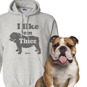 May include: A gray hooded sweatshirt with a bulldog silhouette and the text "I like 'em Thicc". A bulldog is sitting in front of the sweatshirt.