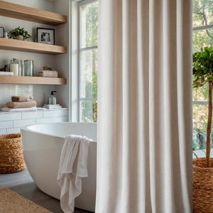 May include: A white bathtub with a white towel hanging over the side. The bathtub is in a bathroom with a window and a shower curtain.