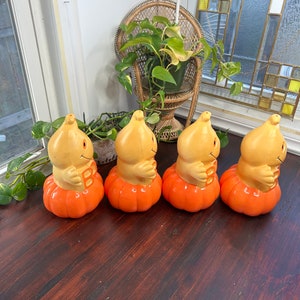 May include: Four orange pumpkin-shaped Halloween decorations with a smiling face and the letter "B" on the front. The decorations are made of plastic and have a vintage look.