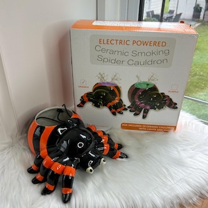 May include: Electric powered ceramic spider cauldron with orange and purple cauldron options. The cauldron is 61 cm long and includes lights and smoke.