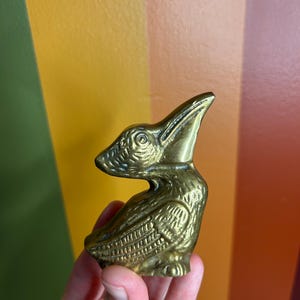 Fermacarte vintage a forma di piccolo pellicano in ottone massiccio con patina.
