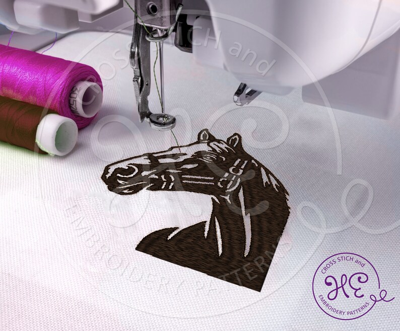 Pu&ograve; includere: Un disegno di ricamo di testa di cavallo marrone che viene cucito su un tessuto bianco da una macchina da cucire. Il disegno &egrave; delineato con filo nero e la testa del cavallo &egrave; rivolta verso il lato sinistro dell'immagine. La macchina da cucire si trova nell'angolo in alto a sinistra dell'immagine. Due bobine di filo sono visibili nell'angolo in alto a sinistra dell'immagine.