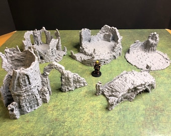 May include: A set of six gray, 3D printed, ruined building pieces for tabletop gaming. The pieces include a tower, archway, bridge, and three different circular platforms.