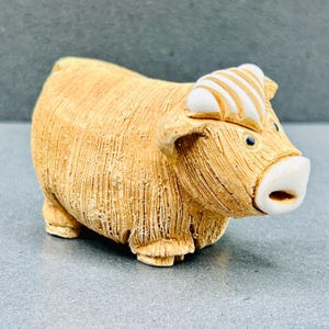 Può includere: Statuetta di mucca delle Highlands in ceramica color beige. La mucca ha un mantello strutturato, un muso bianco e una cresta a strisce bianche e beige. Oggetto decorativo.