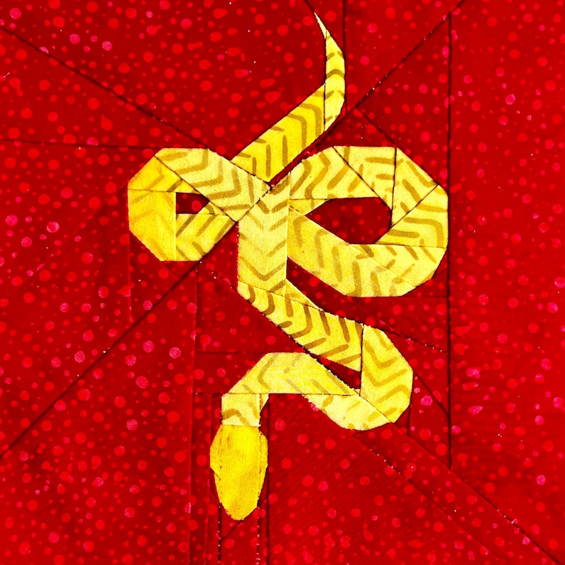 May include: A yellow snake with a chevron pattern is on a red background with white polka dots.