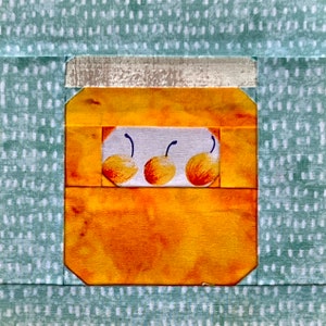 Könnte beinhalten: Ein gelbes und oranges Glas mit Deckel, das drei gelbe Birnen enthält. Das Glas befindet sich auf einem hellblauen Hintergrund mit weißen Punkten.