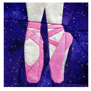 Könnte beinhalten: Ein Paar rosa Ballettschuhe aus Stoffresten, mit weißem Hintergrund und dunkelblauem Hintergrund mit goldenen Glitzer.