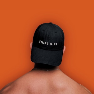 Könnte beinhalten: Eine schwarze Baseballkappe mit dem Schriftzug "FINAL GIRL" in weiß auf der Vorderseite.