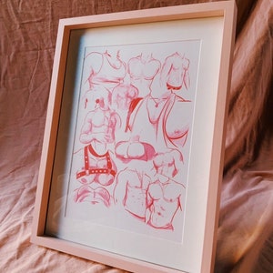 May include: A framed art print with red sketches of torsos. The artwork is presented in a light pink frame with a white mount. The sketches depict various body types and poses. The frame is a soft pink colour.