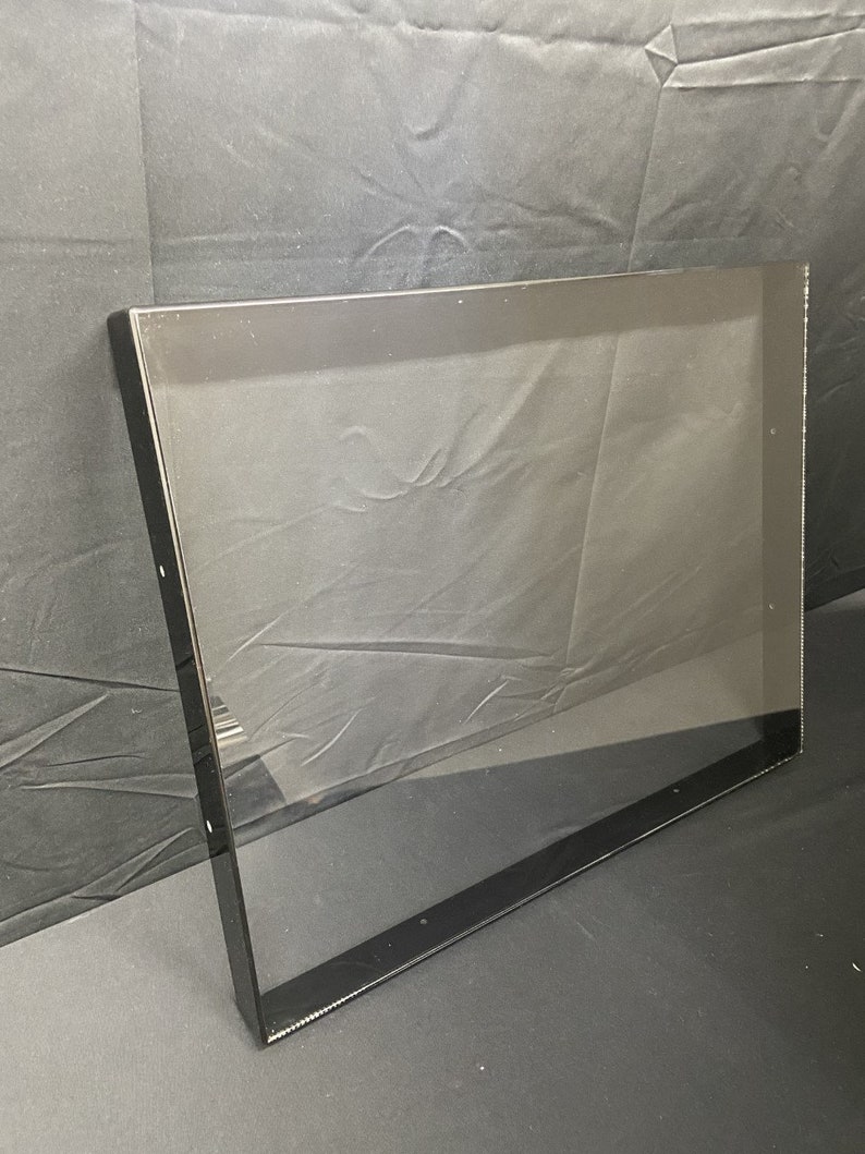 May include: A black framed picture frame with a clear glass insert. The frame is made of a thin, black metal and has a simple, modern design.