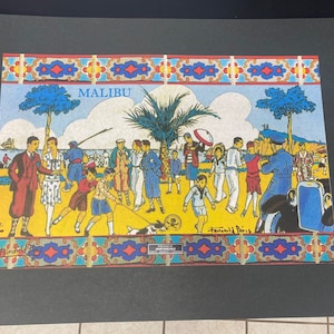 May include: A colorful vintage illustration of people on a beach in Malibu, California. The illustration features a palm tree, a car, and a group of people in various poses. The text "MALIBU" is written in blue letters at the top of the image.