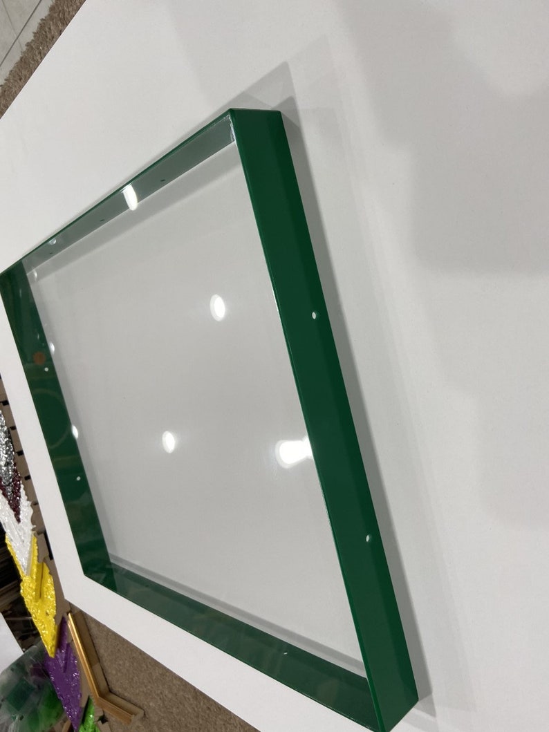 May include: A green metal frame with a square shape. The frame is made of metal and has a smooth, glossy finish.