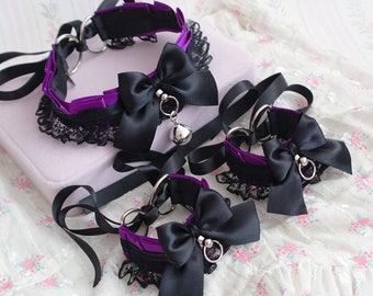 May include: Three black and purple lace chokers with silver bell charms. The chokers are made of satin ribbon and lace.
