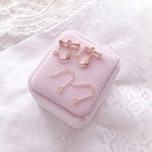 May include: Two gold-tone earring backs and two gold-tone earring wires in a pink velvet box.