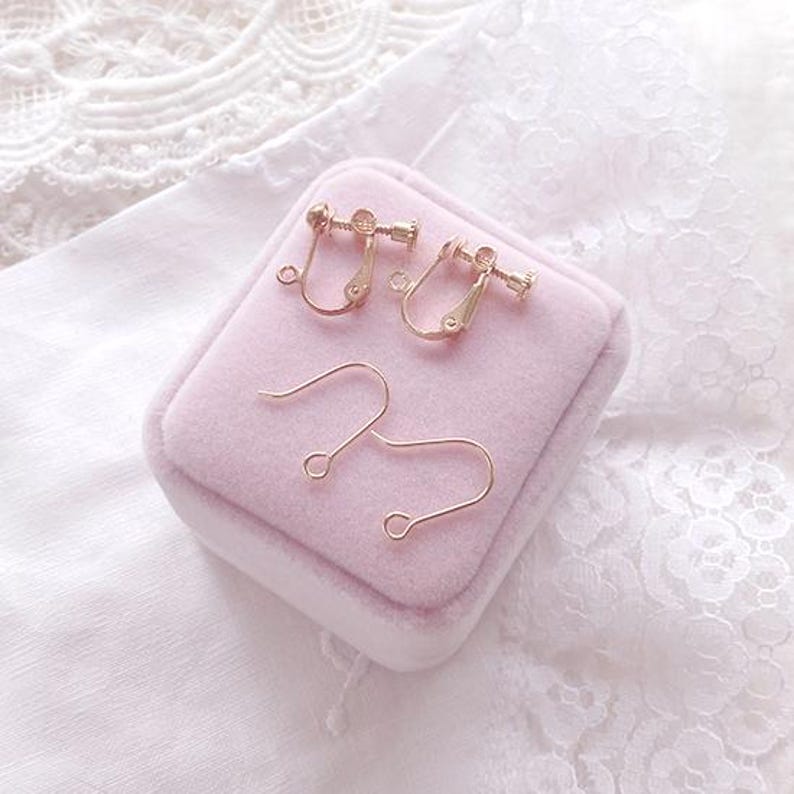 May include: Two gold-tone earring backs and two gold-tone earring wires in a pink velvet box.