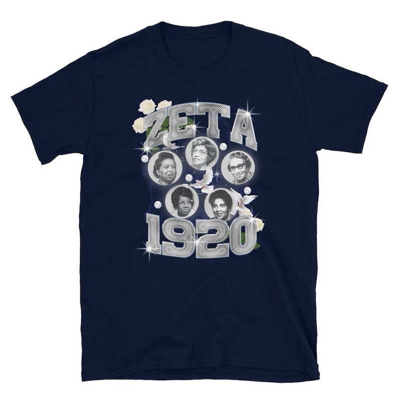 May include: Navy blue t-shirt with a silver design featuring the text "ZETA 1920" and images of four women.