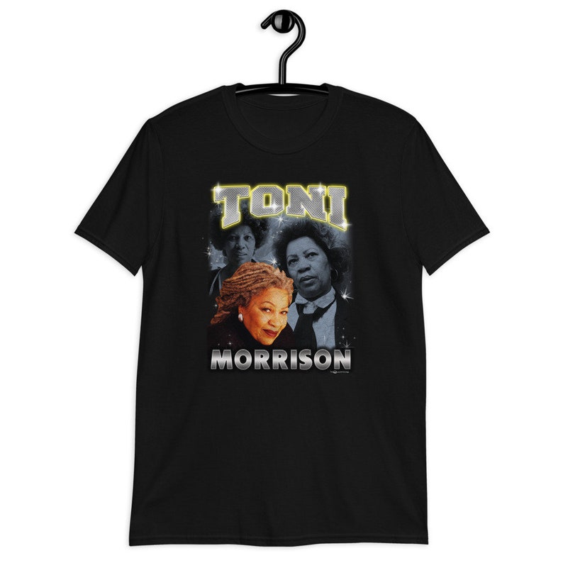 Peut inclure: T-shirt noir avec un graphique de Toni Morrison dans un style r&eacute;tro avec le texte "TONI MORRISON" dans une police scintillante.