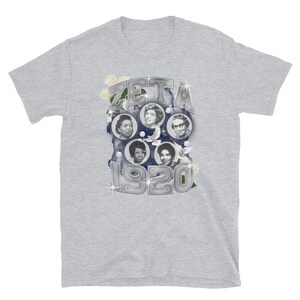 May include: A gray t-shirt with a silver graphic of a circle with the word "ZETA" and the year "1920" in the center. The circle is surrounded by images of five women and white doves.