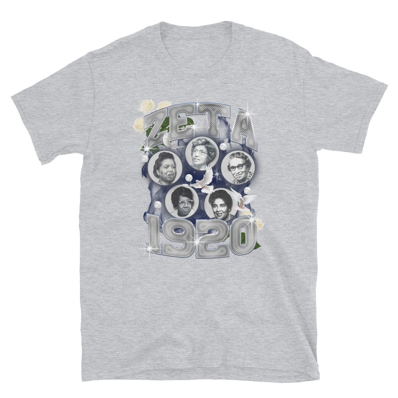 May include: A gray t-shirt with a silver graphic of a circle with the word "ZETA" and the year "1920" in the center. The circle is surrounded by images of five women and white doves.