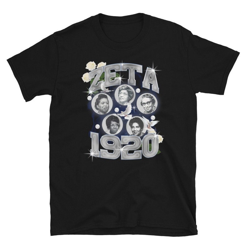 May include: Black t-shirt with a silver design featuring the text "ZETA 1920" and images of five women. The design is surrounded by white flowers and doves.