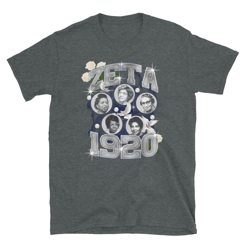 May include: A dark heather grey t-shirt with a silver graphic of the word "ZETA" and the year "1920" surrounded by white flowers and doves. The graphic features four women's faces in circular frames.