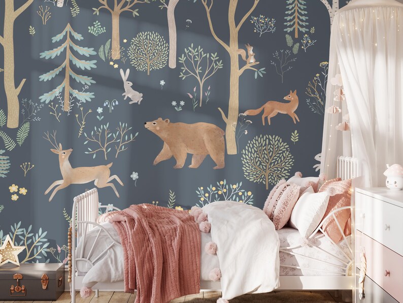 May include: A blue and white wallpaper with a woodland theme. The wallpaper features a bear, a deer, a fox, and a rabbit. The wallpaper is in a child's bedroom with a white bed and pink bedding.