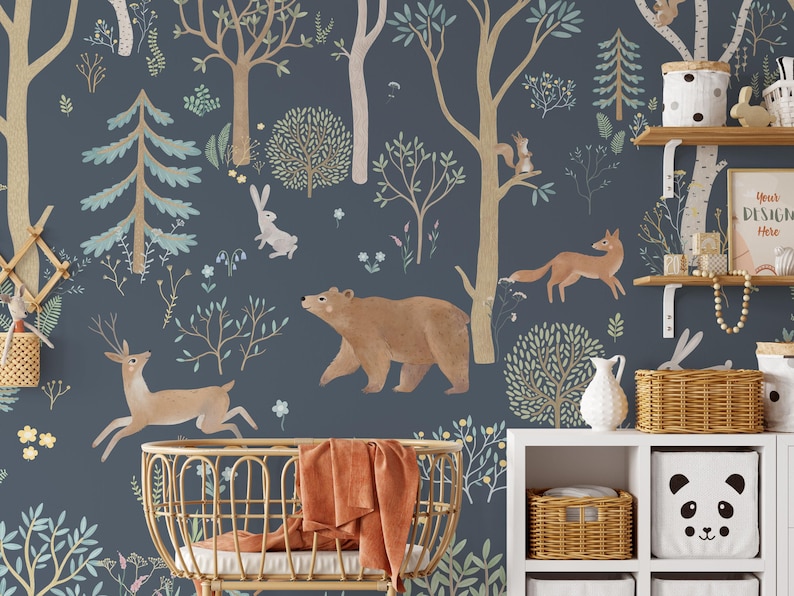 May include: A blue and brown woodland nursery wallpaper featuring a bear, deer, fox, and rabbit. The wallpaper is decorated with trees, flowers, and leaves. The wallpaper is shown in a nursery setting with a cot, shelves, and baskets.