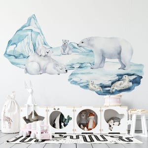 May include: A nursery wall decorated with a watercolour-style mural of polar bears and seals on an iceberg. Below, a white storage unit contains toys, including a plush bunny, a pink wooden truck, and stuffed animals. A white giraffe-printed bag and a small stool are also present.
