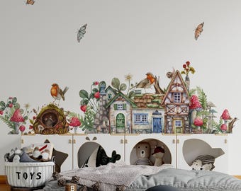 May include: A wall decal set featuring watercolor illustrations of a whimsical village with small houses, red mushrooms, green foliage, and birds. The scene includes a hollow tree trunk with a mouse, butterflies, and detailed timber-framed cottages.