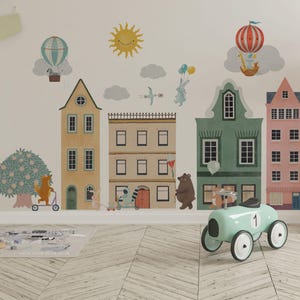 Könnte beinhalten: Ein Wandaufkleber-Set mit einer Stadtszene mit bunten Gebäuden, einer gelben Sonne, Wolken und Tieren, darunter ein Fuchs auf einem Roller, ein Hase, ein Waschbär und ein Bär. Heißluftballons, ein Vogel und ein hellblaues Rutschauto sind enthalten.