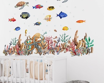 May include: A wall decal set featuring a vibrant underwater scene with sea turtles, various colorful tropical fish, an octopus, coral reefs, and sea plants. The design includes scattered bubbles and is displayed above a white wooden crib.