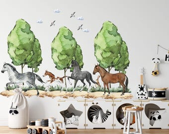 May include: A wall decal featuring a watercolor illustration of four horses in a grassy field with green trees and small clouds. The scene includes a grey horse, a brown and white foal, a black horse, and a brown horse, all standing on a dirt path.
