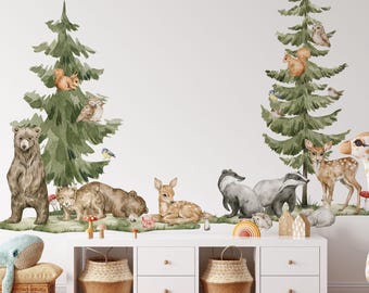 May include: A wall decal set featuring watercolor illustrations of forest animals including a bear, deer, badger, squirrel, and owl, arranged around two green pine trees. The design includes small red mushrooms and flowers.