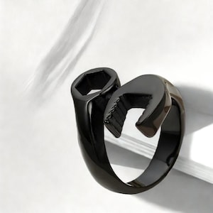 May include: Black metal ring shaped like a wrench.