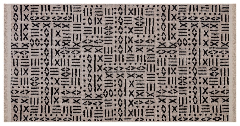 May include: A beige rug with a black geometric pattern. The pattern is made up of lines, squares, and diamonds.