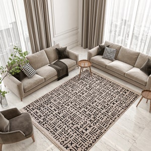 May include: A beige and black patterned rug with a geometric design. The rug is laid out on a light gray tiled floor in a living room setting with two beige sofas and a wooden side table.