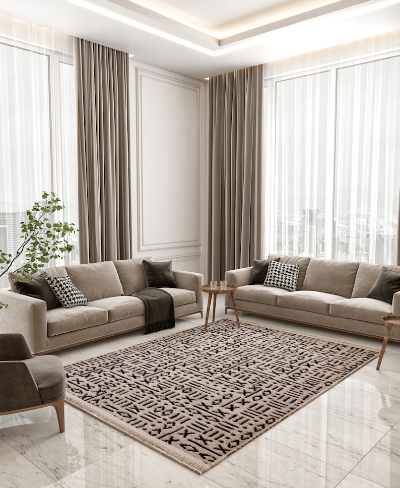 May include: A living room with two beige sofas, a patterned rug, and a small table with two glasses. The room has large windows with sheer curtains and beige drapes.