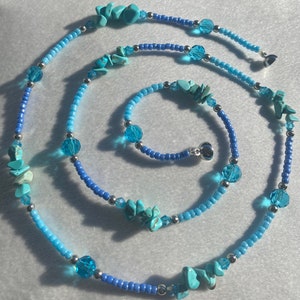 May include: Two turquoise and blue beaded necklaces with silver accents. The larger necklace has larger turquoise stones and the smaller necklace has smaller turquoise stones.